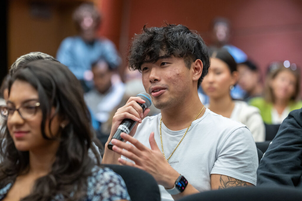 Audience member asks question at a Distinguished Speaker Series event about reproductive health.